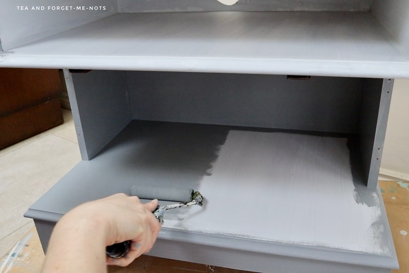 Applying a coat of primer to the tv cabinet