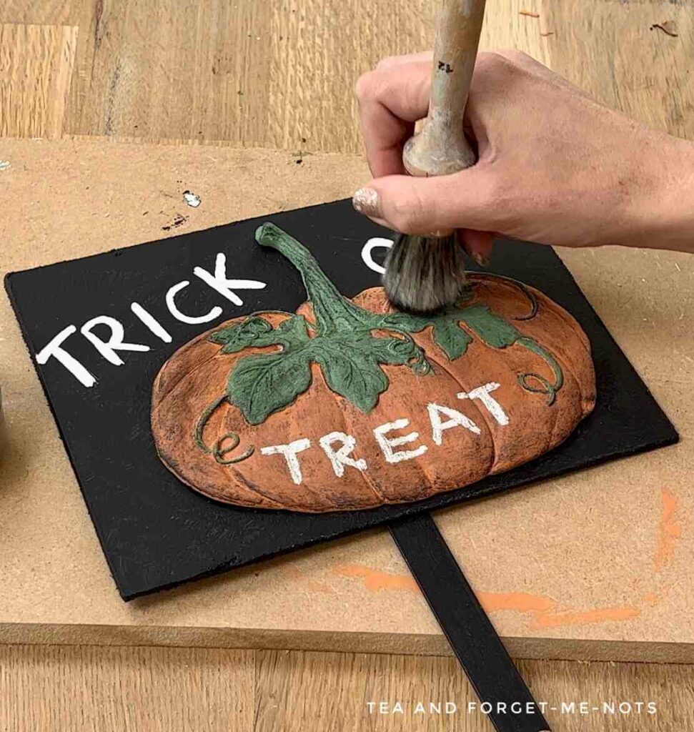 Applying black wax to add texture to pumpkin mold