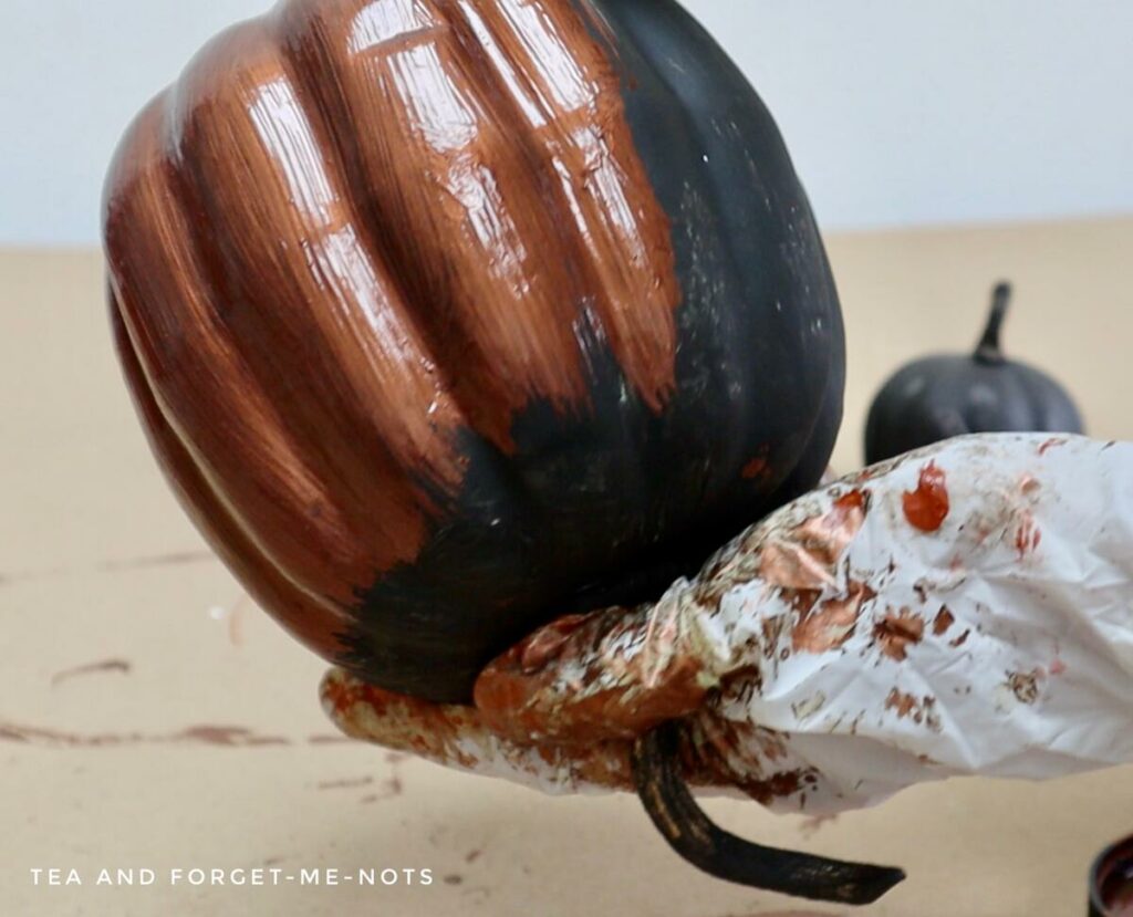 Applying patina paint to pumpkins