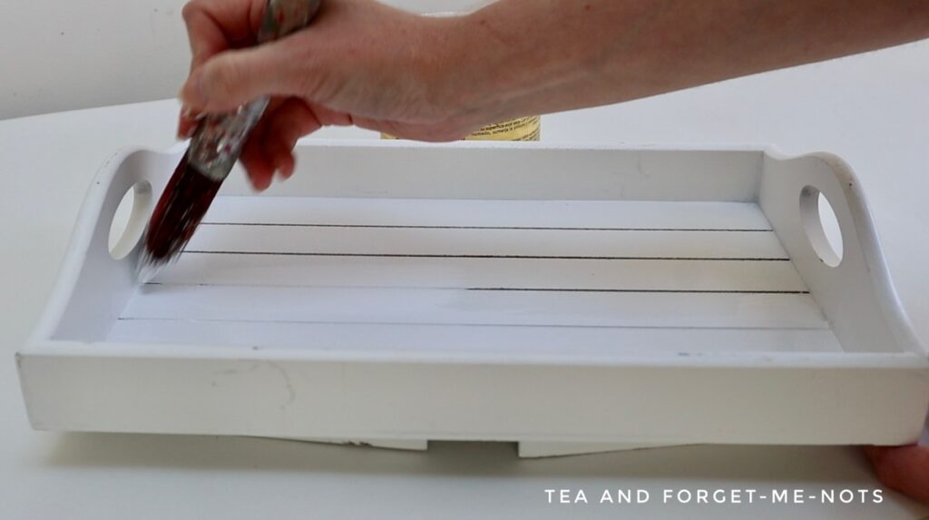 Applying white paint to breakfast table tray