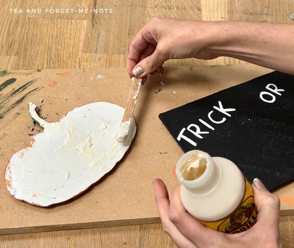 Attaching clay mould to diy halloween porch sign with wood glue