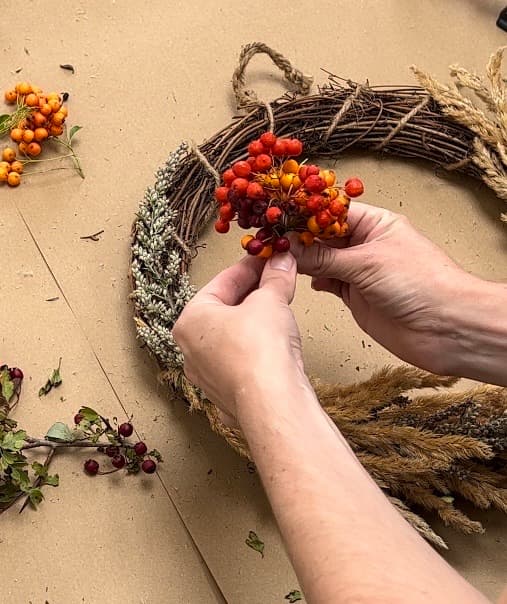 adding berries to autumn wreath