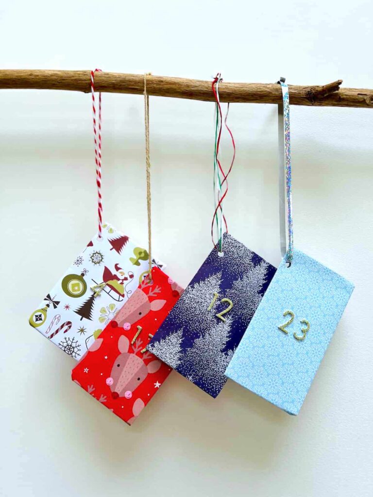 add ribbons to advent calendar pouches