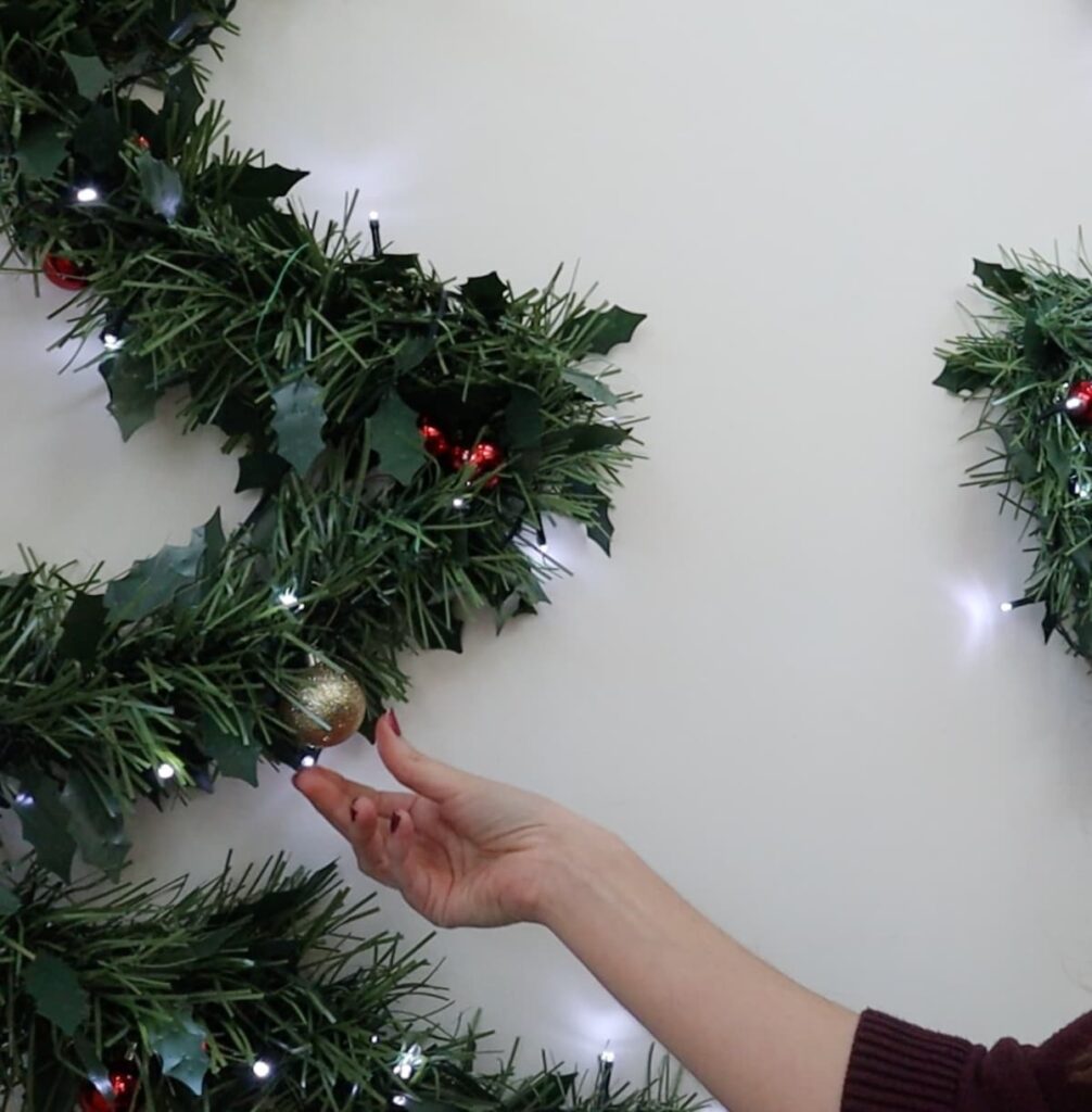 add small ornaments to wall christmas tree