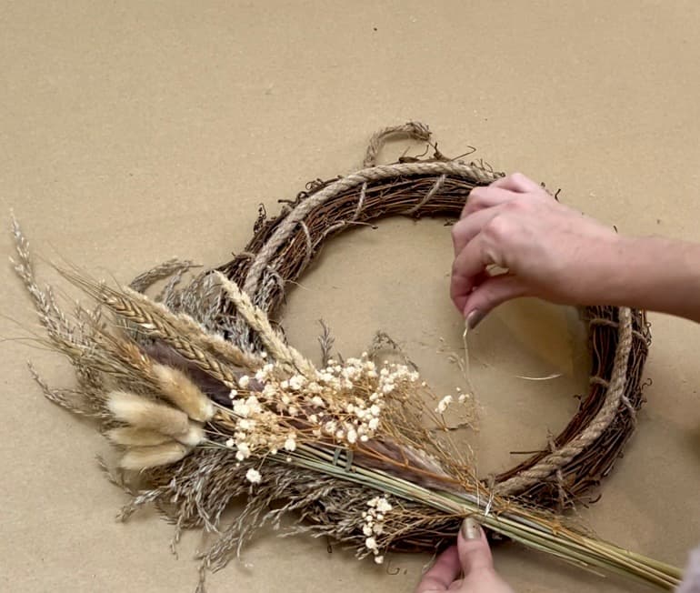 adding flowers to wreath