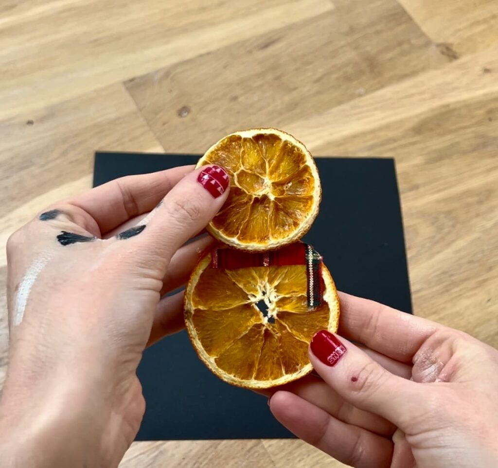 glue orange slices together into snowman shape