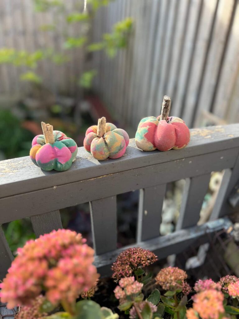 side view of rainbow painted concrete pumpkins
