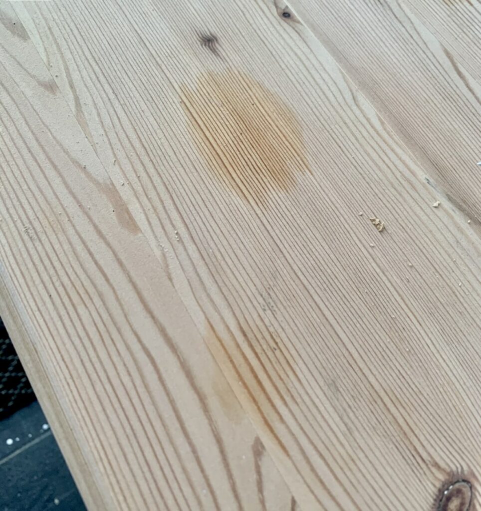 image shows piece of wood with stains.