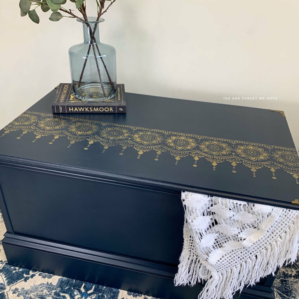 painted mdf chest with navy blue paint and gold details.