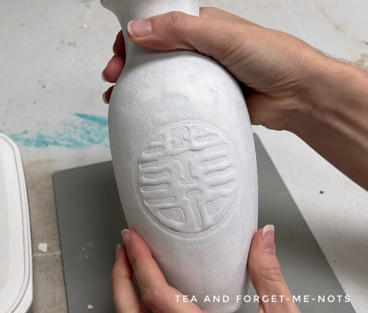 applying slick stick to the ceramic vase