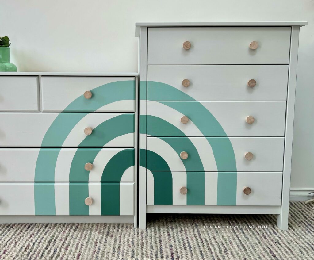 image shows white painted drawers with a rainbow on both.