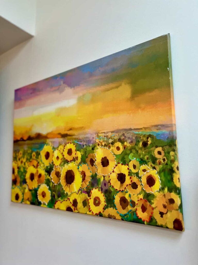 finished canvas with decoupaged sunflowers and threaded line art.