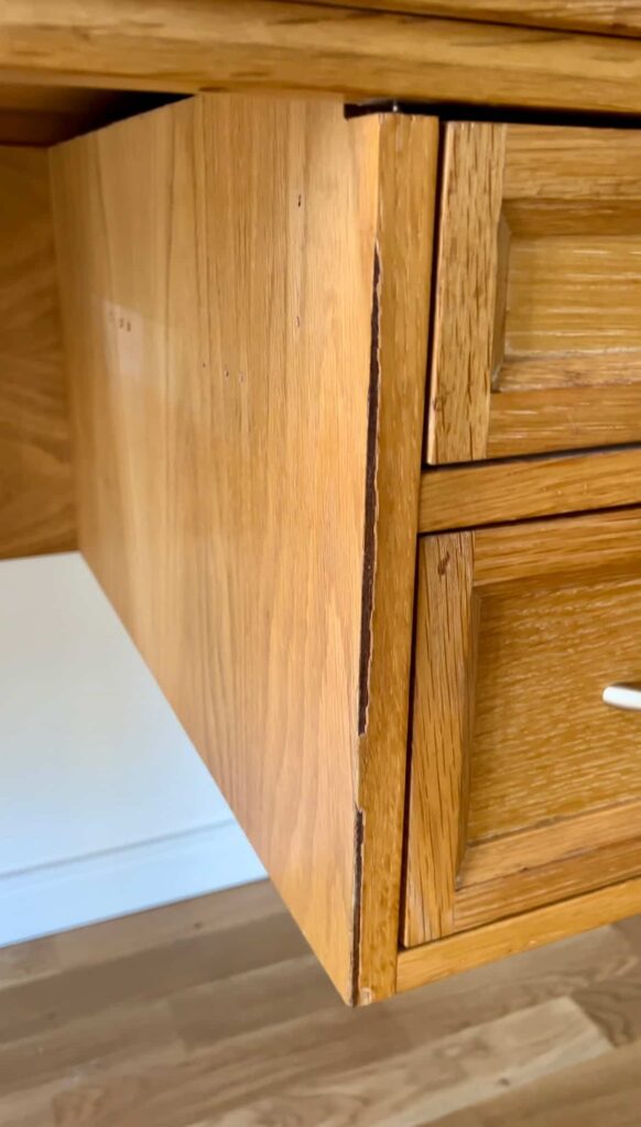 close up showing damaged veneer on desk.