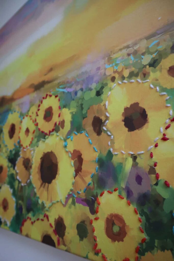 close up on minimalist embroidery on canvas of sunflowers.