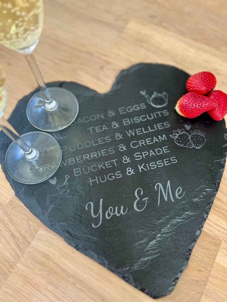 engraved slate with a drink and strawberries on top.