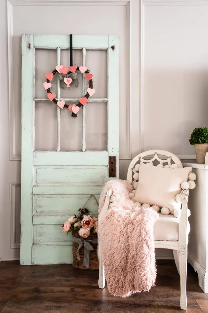 image shows wreath made up of heart shapes on green door.