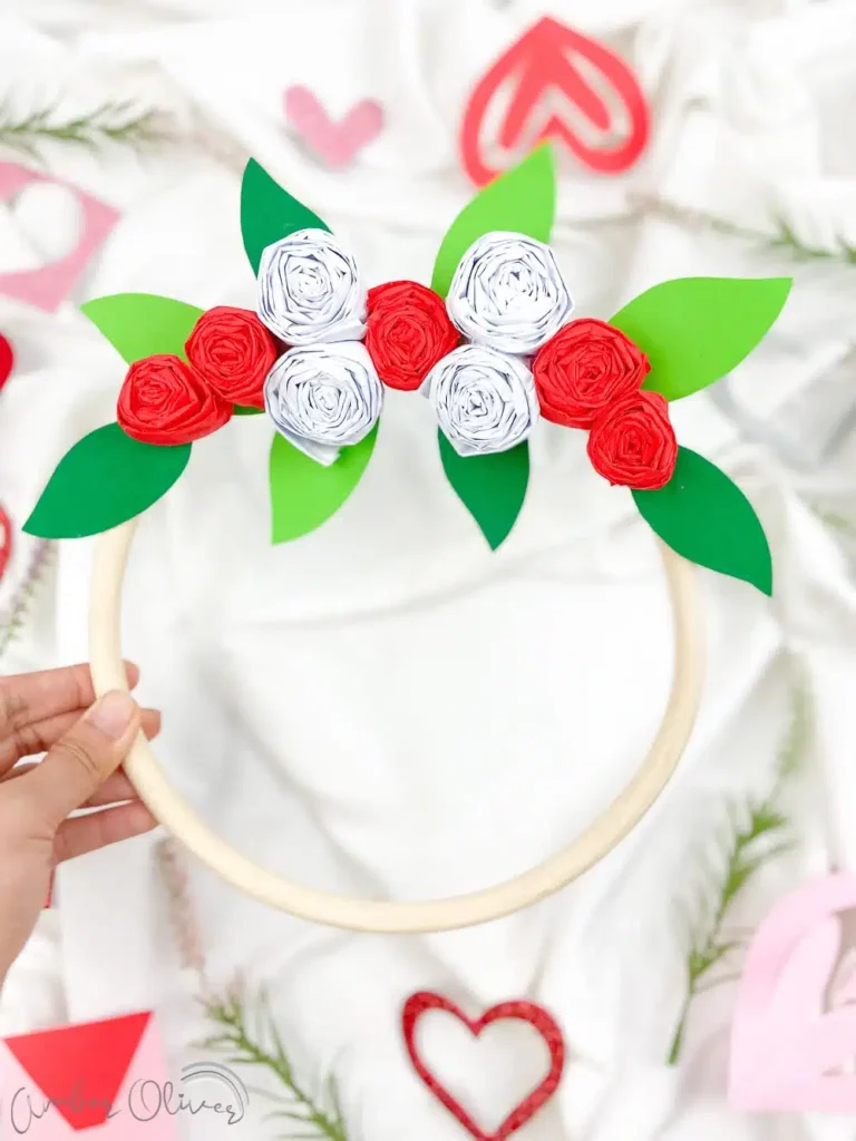 image shows white wreath with diy foliage on the top.