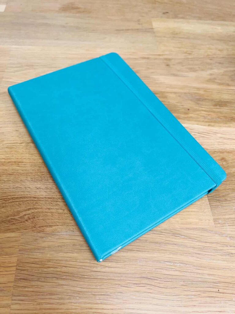 image shows blue faux leather notebook.