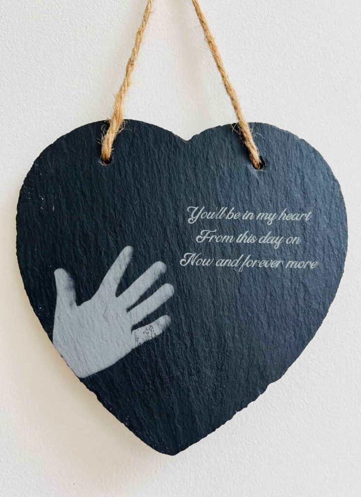 image shows engraved slate heart with handprint and quote.
