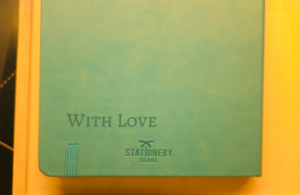 image shows notebook with words 'with love' engraved on the bottom.