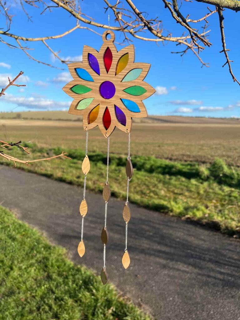 suncatcher hanging in tree in front of a field.