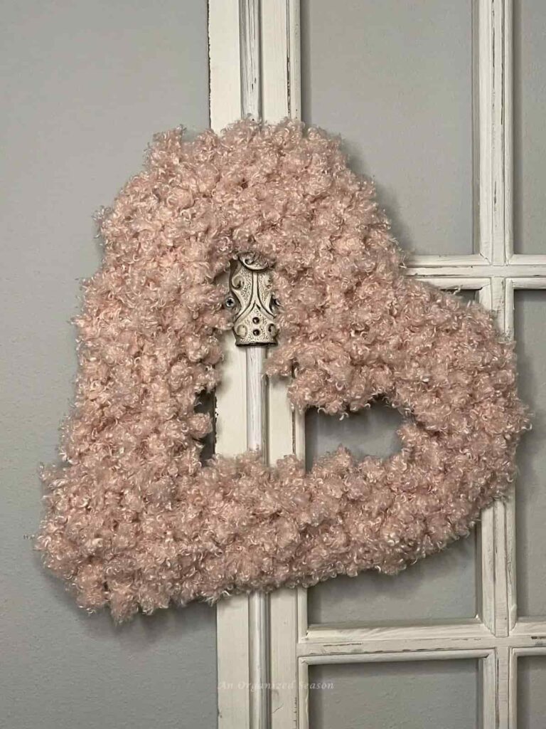 image shows heart wreath made with teddy bear yarn hanging on one side.
