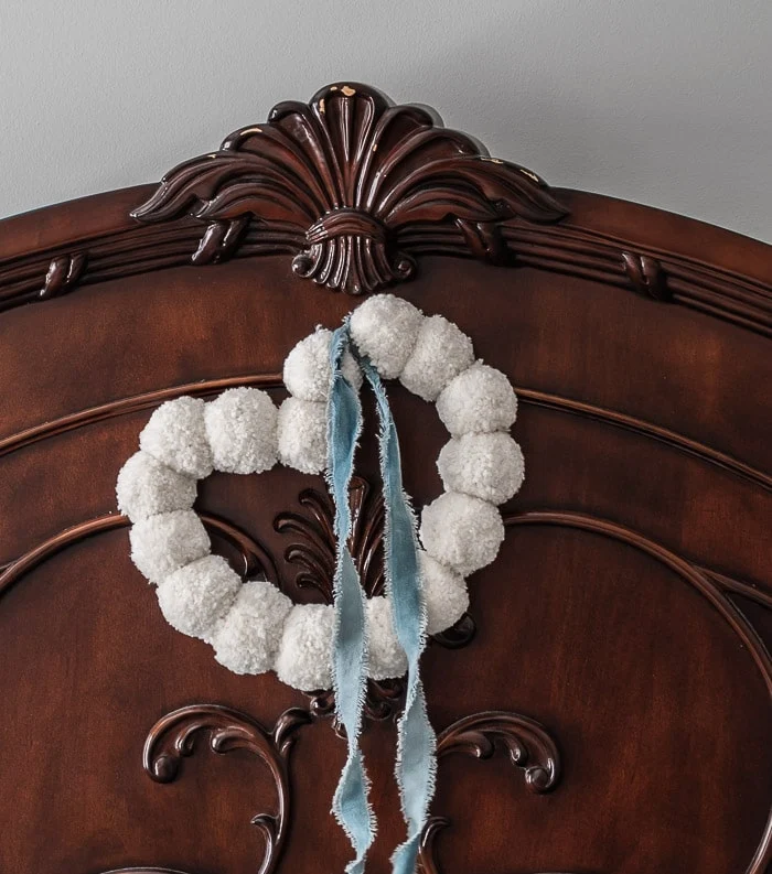 image shows white pom pom wreath.