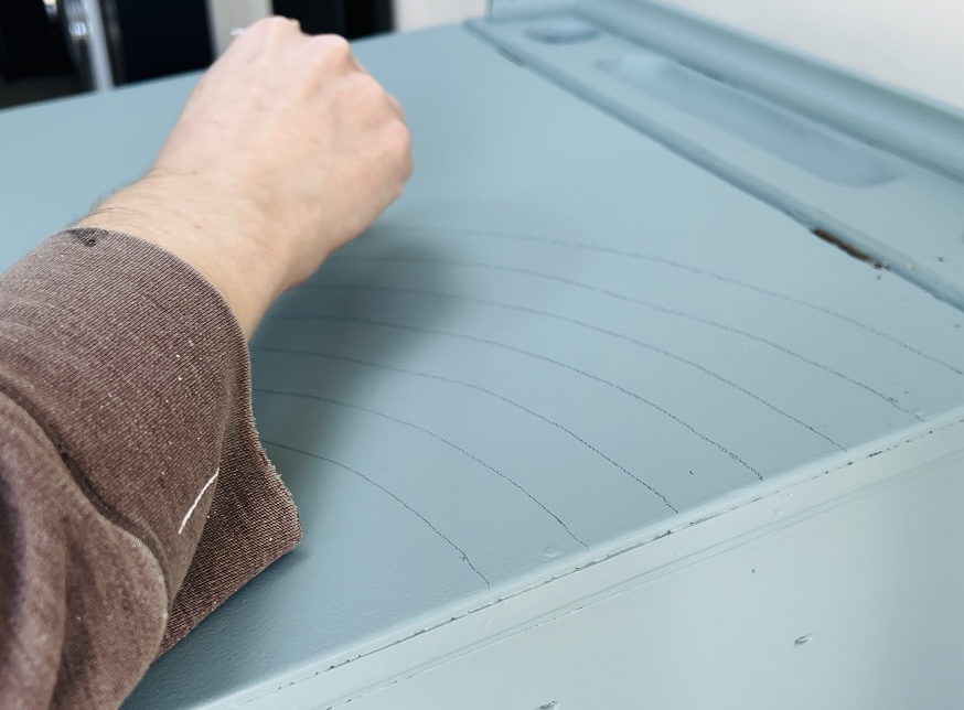 image shows using a pencil to mark out lines of a rainbow on a desk.