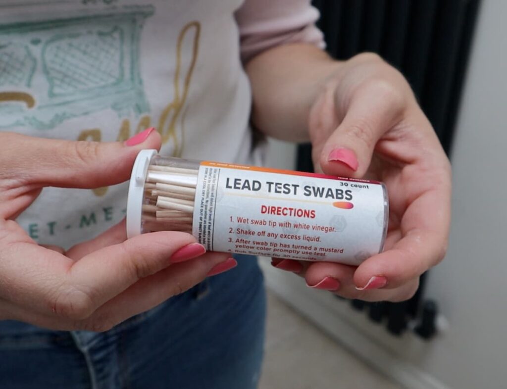 image shows person holding a home lead paint testing kit.
