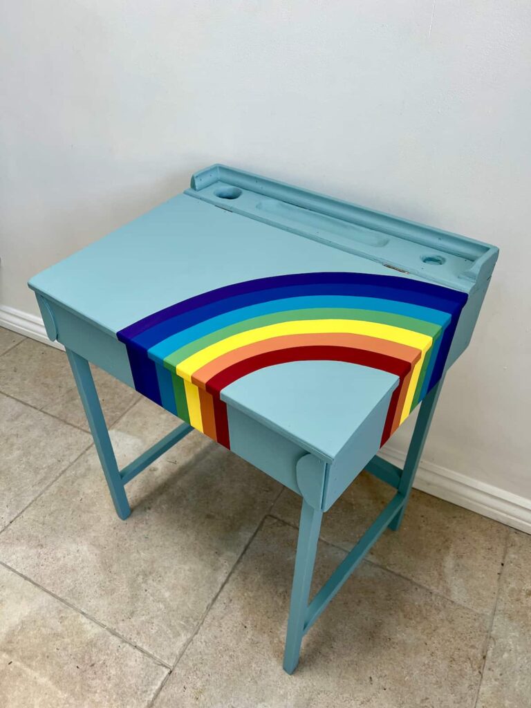 images shows desk painted with curved lines in rainbow colours.