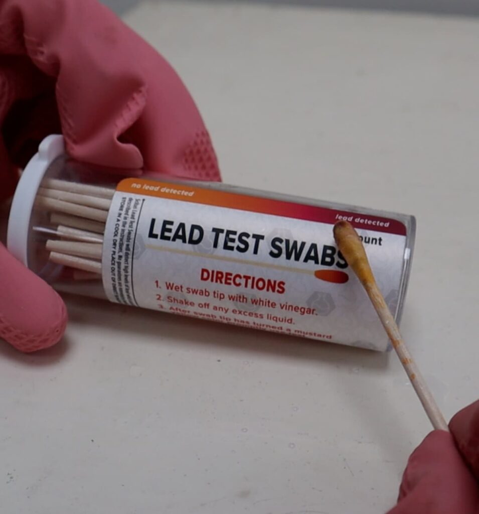 image shows the swab against the lead paint test kit showing that it had traces of lead on it.