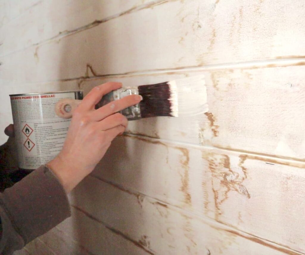 image shows using stain blocker to hide water stains on painted wall.