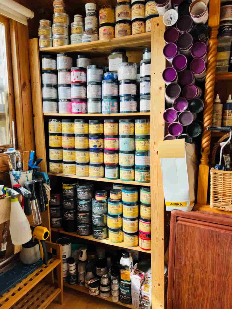 image shows paint supplies organised on shelves.