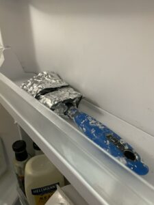 Photo of a used paintbrush in the fridge in foil
