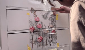 Applying the transfer to the floral chest of drawers