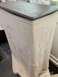 Wrapped the bookshelf in a sheet to protect the paint during sanding