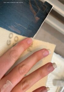 Sanding the edges of the upcycled pine chest of drawers