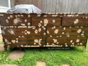 Adding wood filler to the dents of the pine chest of drawers 