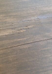 The crack in the poor quality wood after filling with stain