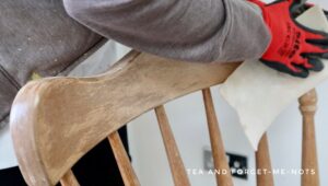 Hand sanding the wooden chair
