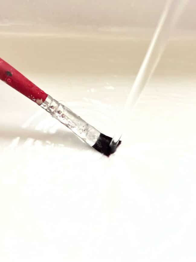 Cleaning paintbrush with water
