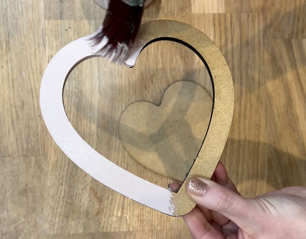 Image shows painting mdf heart with pink paint.