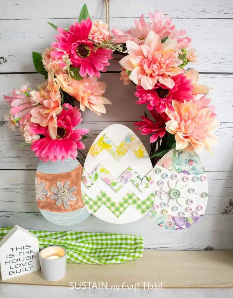 image shows wreath with faux florals and paper eggs.
